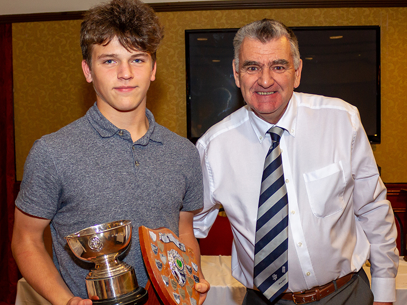 Sam Russell collecting two of his awards from Bovey Tracey chairman Nigel Mountford at the club