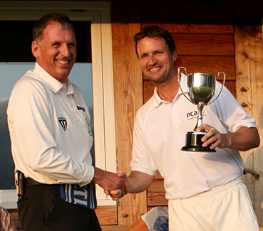 Winning captain David Townsend (right) collects the cup from umpire Andy Forward