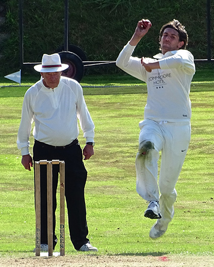 John Silver umpiring North Devon's game against Hatherleigh last season. Jack Popham is the bowler