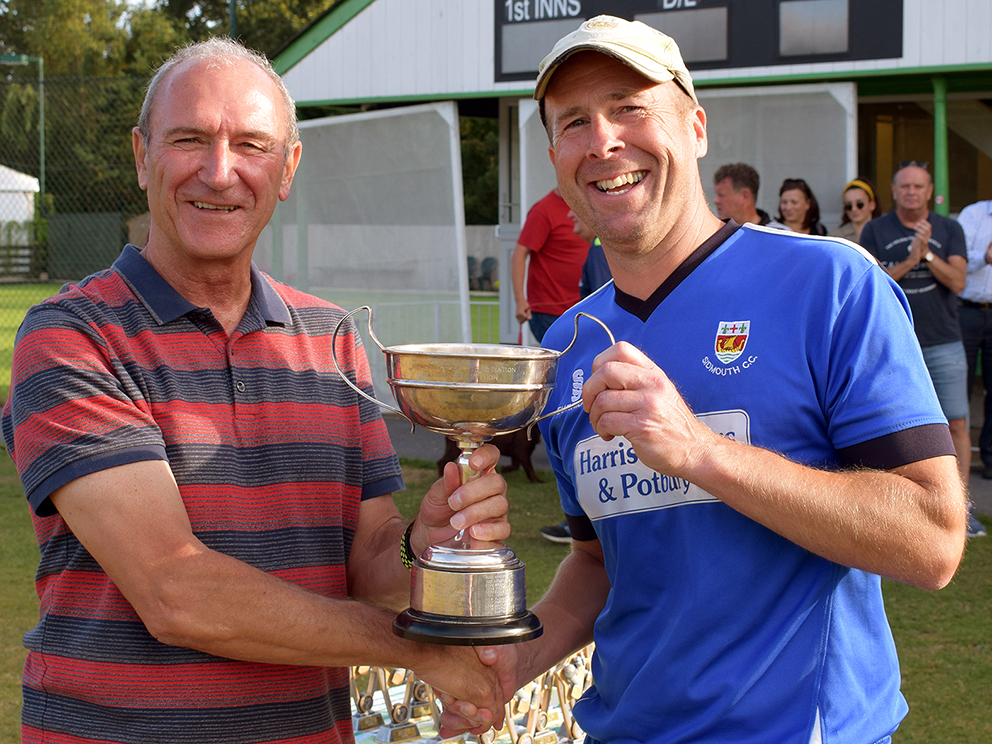 Devon League official Phil Bees (left) hands the Corinthian Cup to Sidmouth 2nd XI captain Anthony Griffiths<br>credit: Conrad Sutcliffe