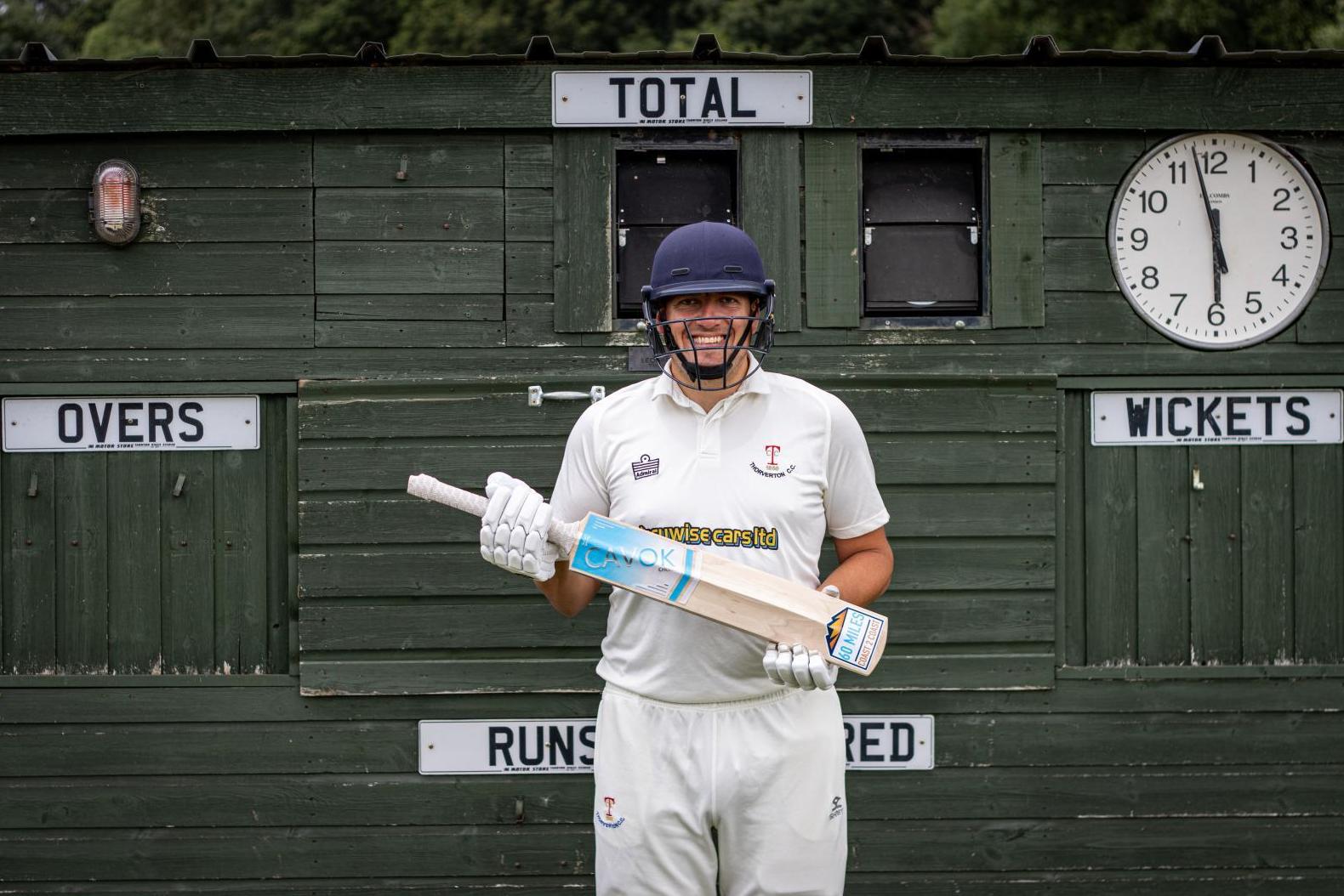Dan poses with the bat produced by Wombat Cricket for the challenge.