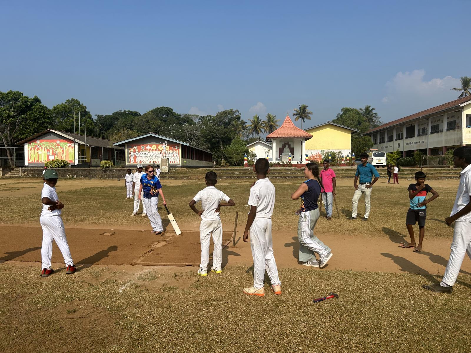 Playing cricket on school grounds.