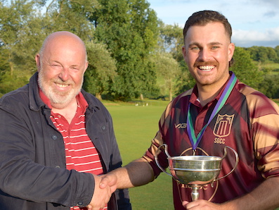Tolchards DCL secretary David Sheppard presents the Corinthian Cup to Stoke Gabriel captain Jack Tolley (right)
